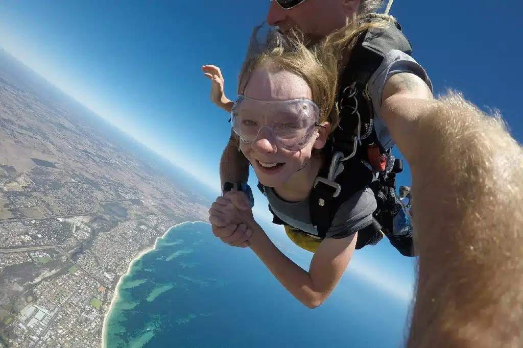 Boy skydiving with his father.