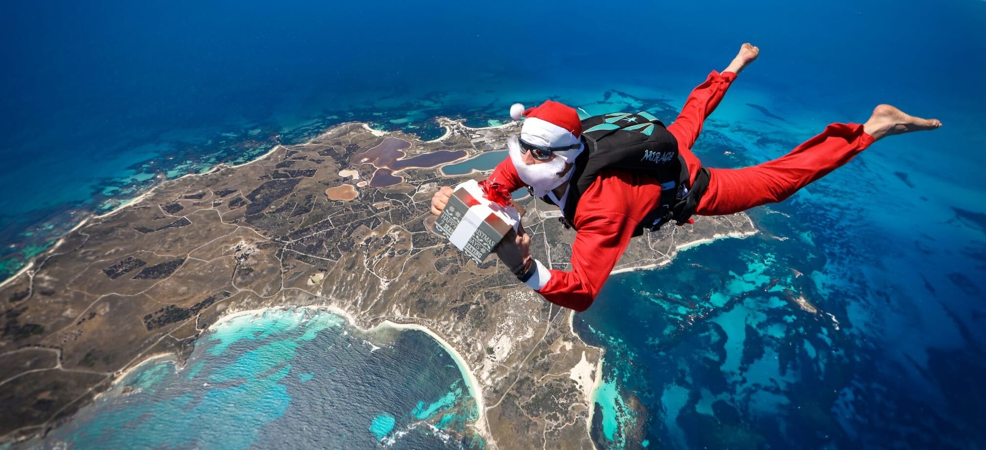 Santa with a present skydiving over rottnest